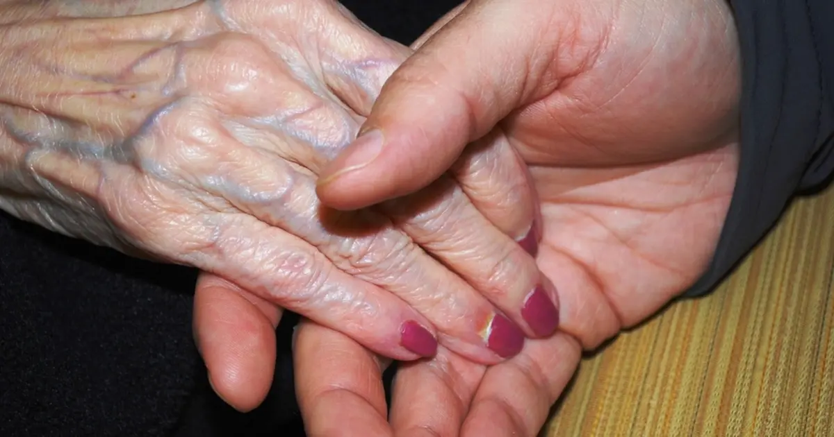 Mãos jovens segurando as mãos de uma pessoa idosa
